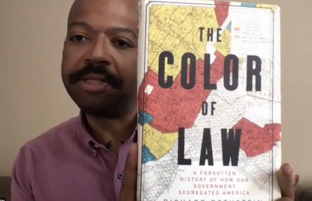 Kevin Tyler showing off the book The Color of Law