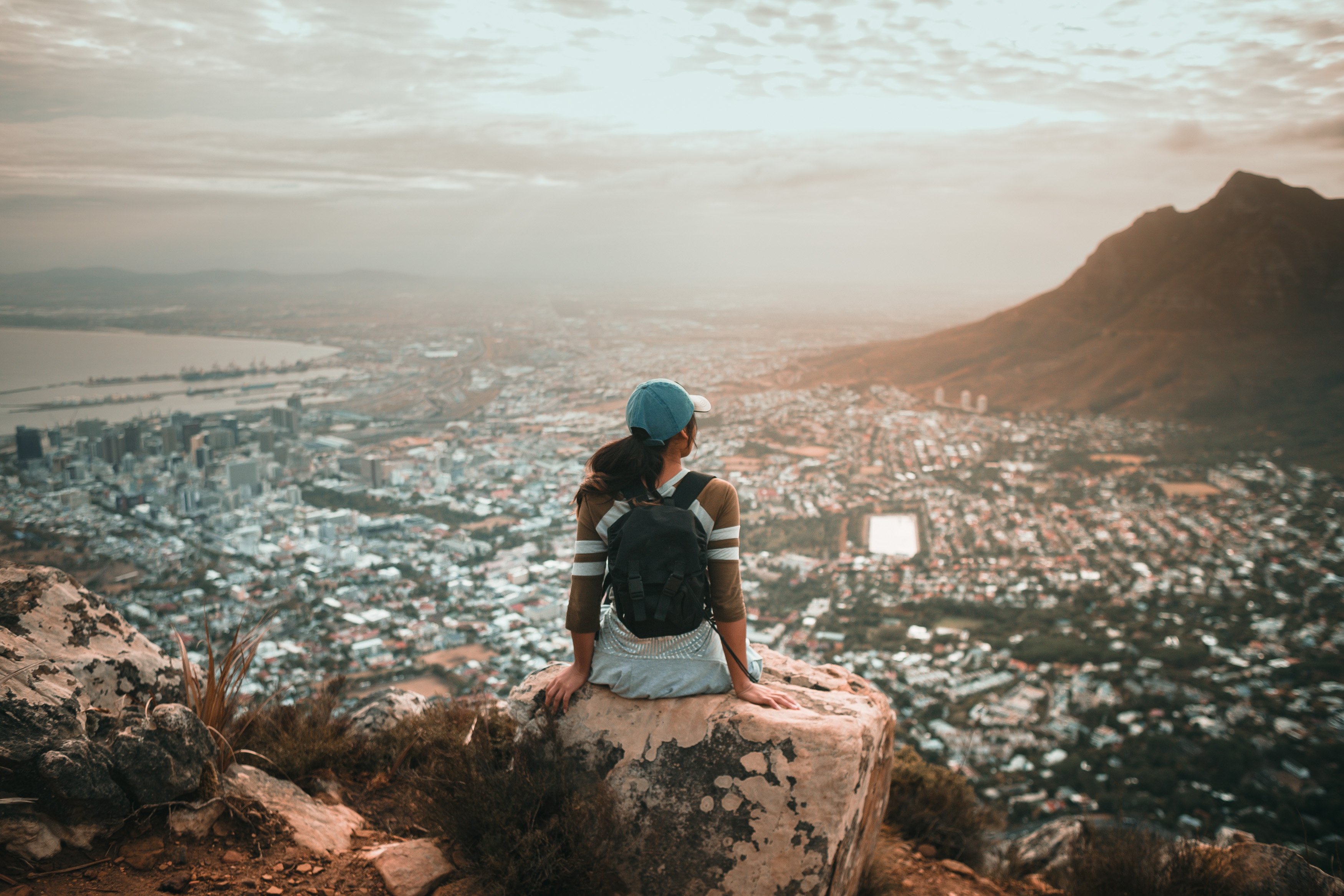 young-woman-relaxing-on-rock-above-city-